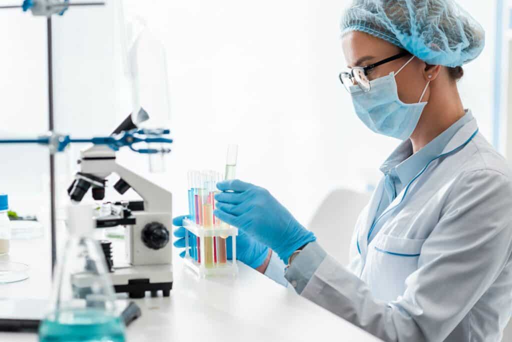 side-view-of-biologist-looking-at-test-tube-in-lab-